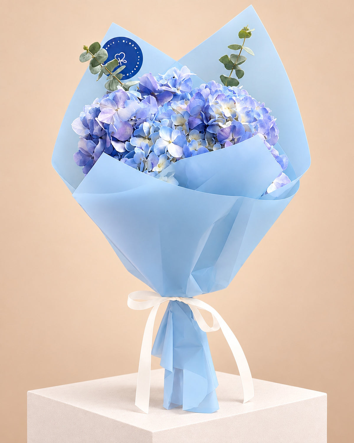 Ramo de hortensias azules con eucalipto en envoltura celeste - Florería Bloom