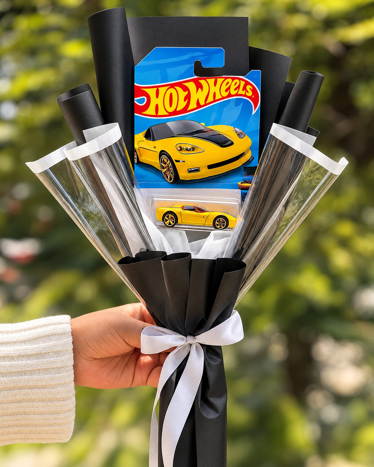 Ramo con carrito Hot Wheels en envoltura negra y lazo blanco - Florería Bloom Lima